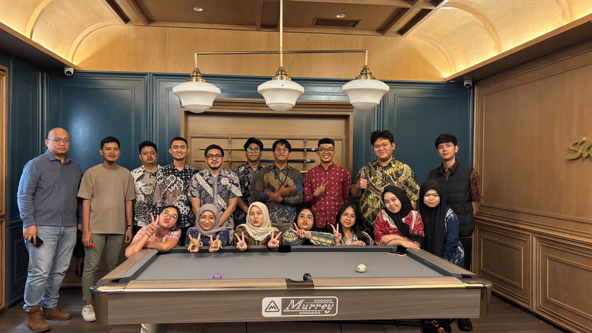 PILARR team gathered for a group photo around a pool table